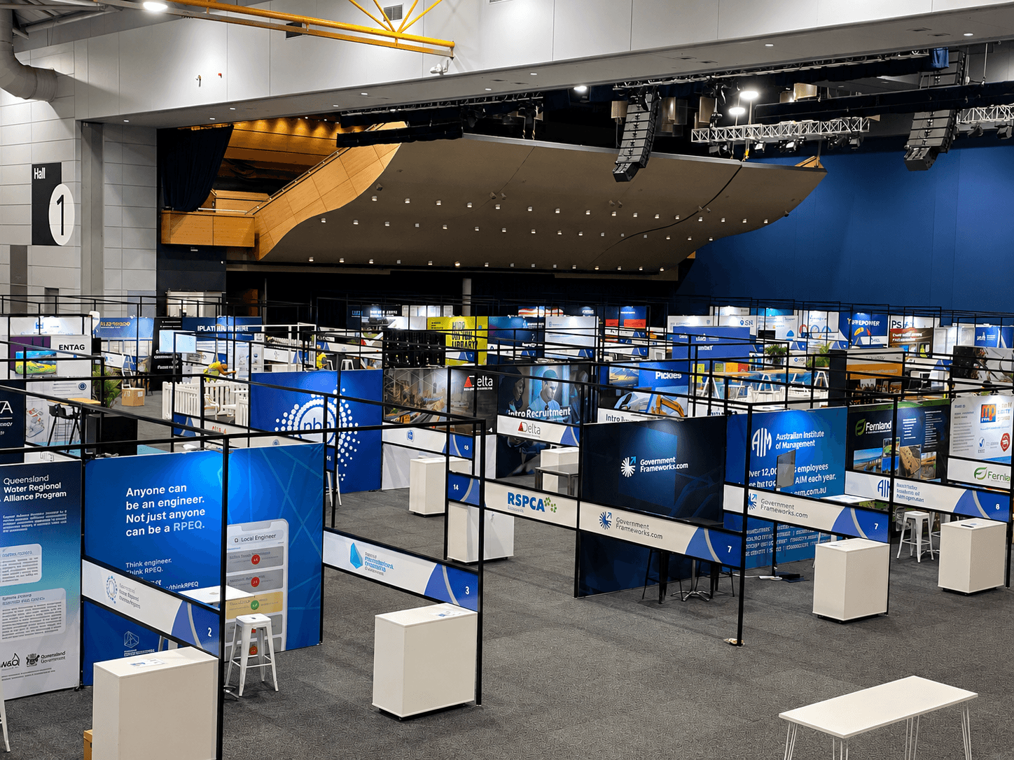 Exhibition hall filled with printed stand walls and signage